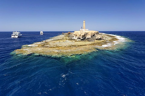 Small island and reef in ocean, lighthouse and dive boats, top scuba diving location, Big Brother of The Brothers Islands or El Akhawein, Red Sea, Egypt, Africa